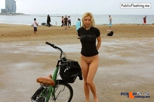 Bottomless blonde and a bicycle on the beach